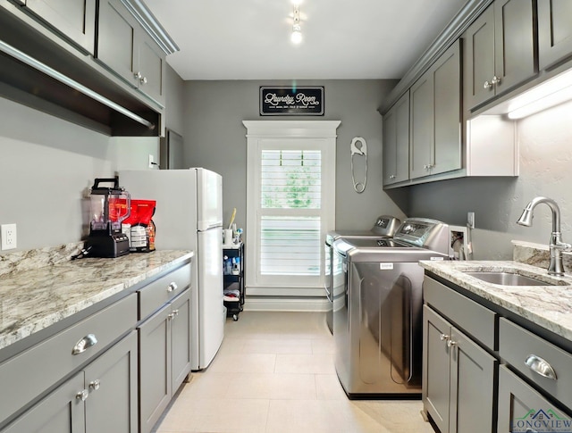 laundry room with cabinet space, a sink, and independent washer and dryer