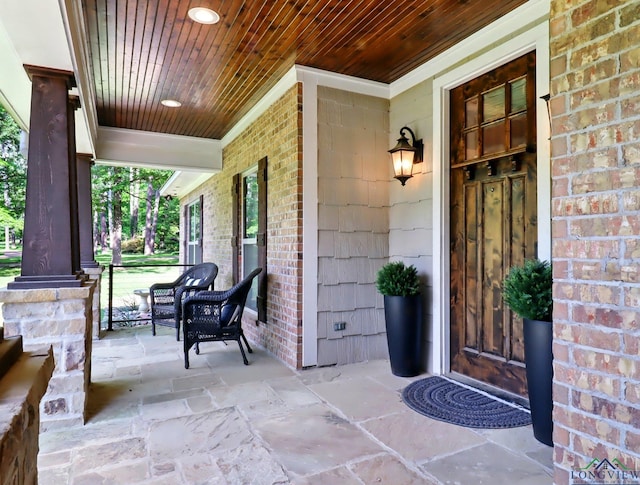 entrance to property featuring brick siding and a porch