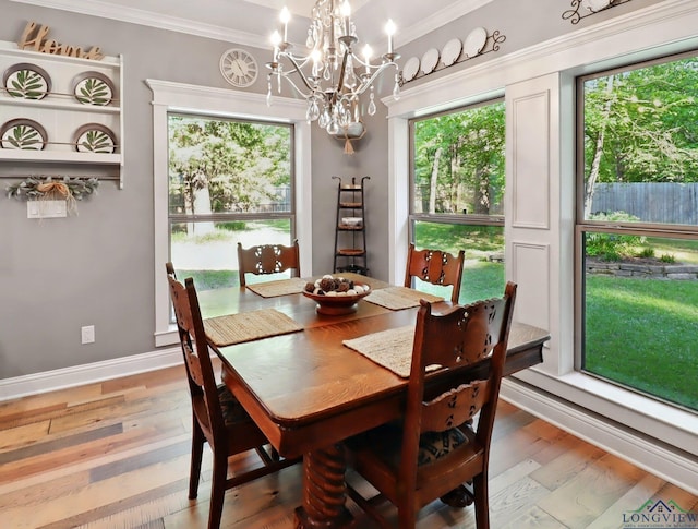 dining room with crown molding, light wood-style flooring, baseboards, and a notable chandelier