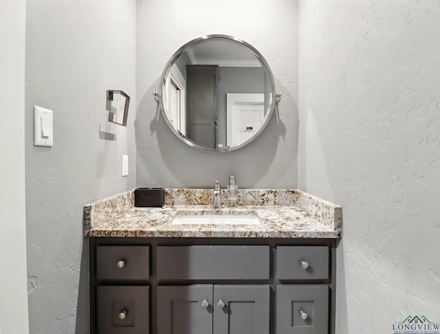 bathroom with a textured wall and vanity