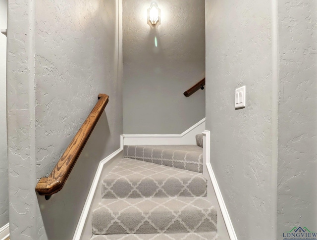 stairs featuring carpet flooring and baseboards