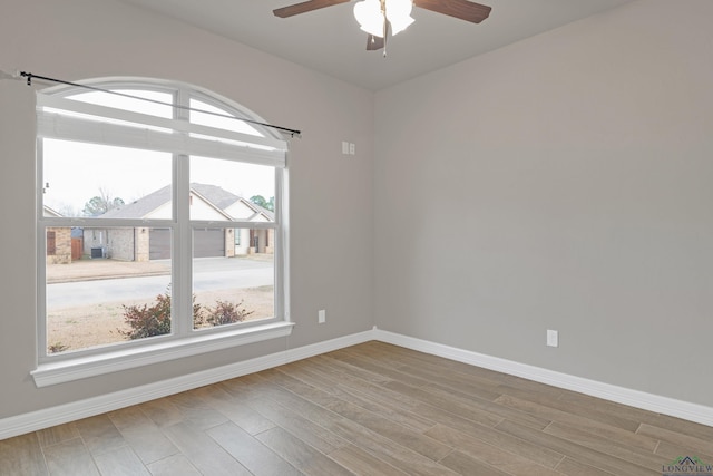 empty room with ceiling fan and light hardwood / wood-style flooring