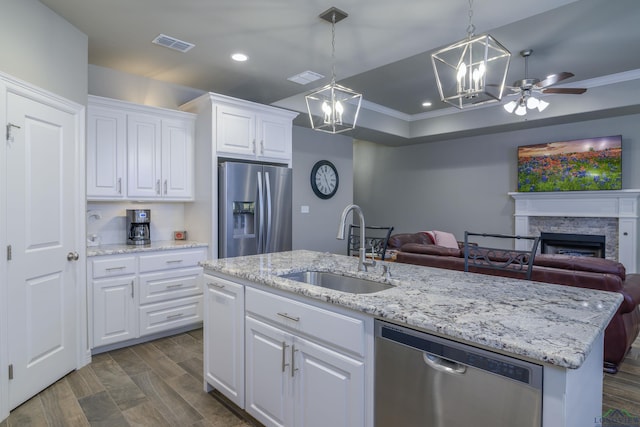 kitchen with sink, white cabinetry, a center island with sink, pendant lighting, and stainless steel appliances