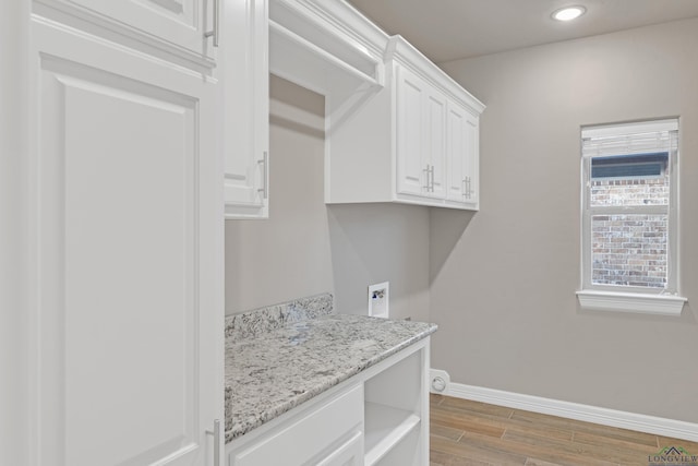 laundry area featuring cabinets, hookup for a washing machine, and light hardwood / wood-style floors