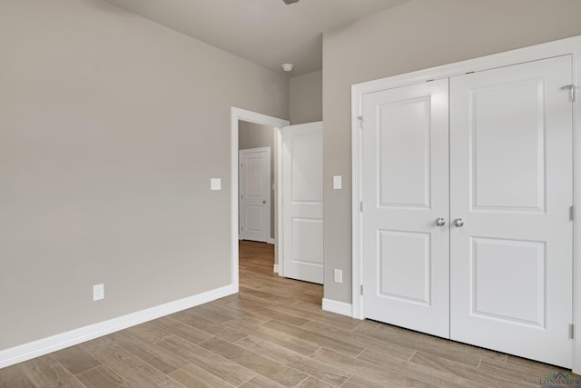 unfurnished bedroom with light hardwood / wood-style floors and a closet