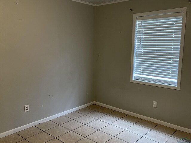 spare room featuring light tile patterned floors and ornamental molding