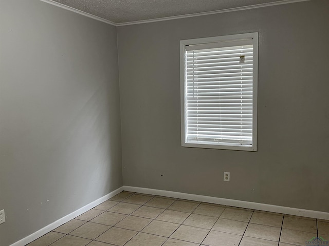 tiled empty room with a textured ceiling and ornamental molding