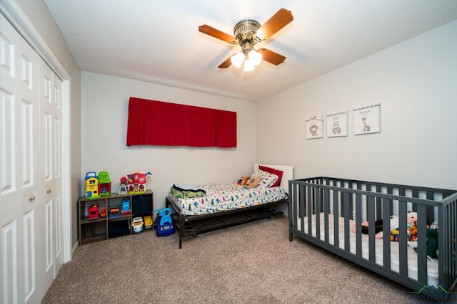 bedroom with ceiling fan, a closet, carpet, and a nursery area