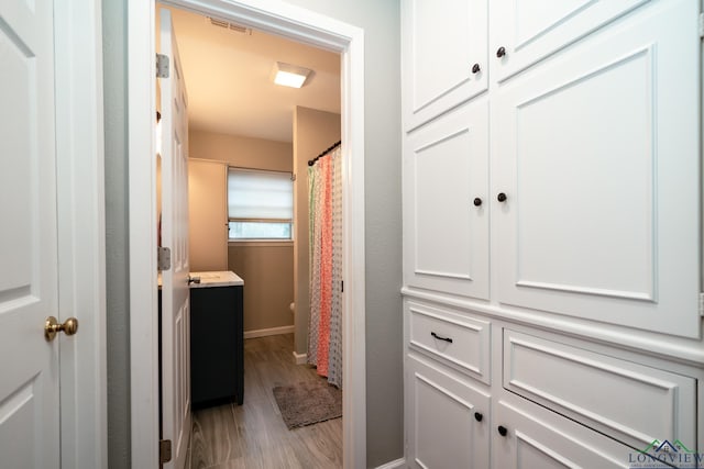 bathroom with toilet, vanity, and hardwood / wood-style flooring