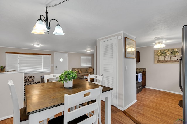 dining space featuring light hardwood / wood-style floors and an inviting chandelier