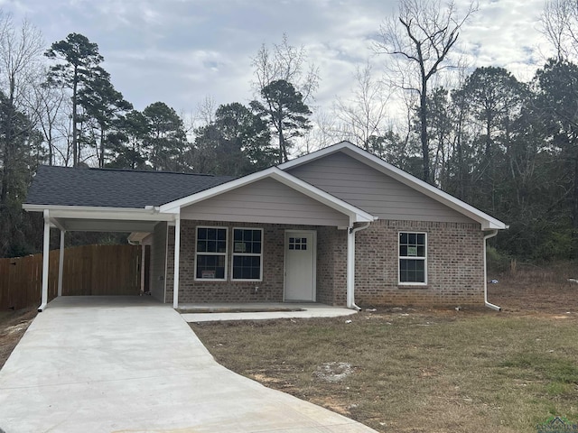 ranch-style home featuring a front lawn, a porch, and a carport