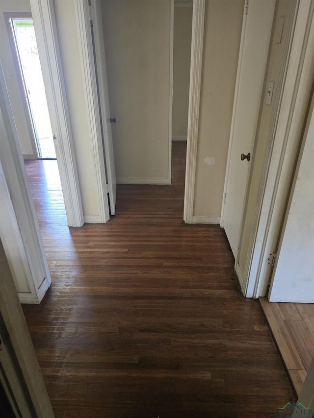 hall with dark wood finished floors and baseboards