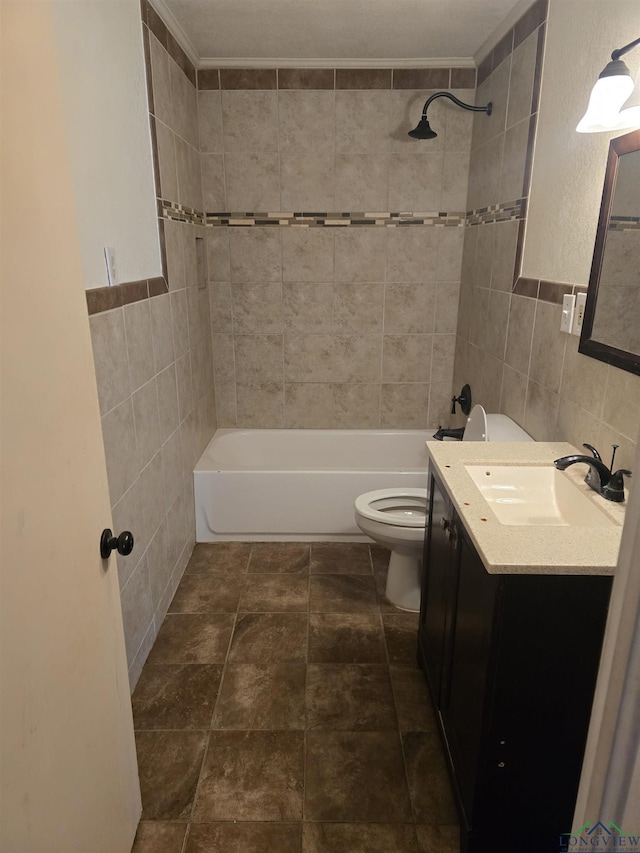 full bath featuring toilet, shower / washtub combination, vanity, and tile walls