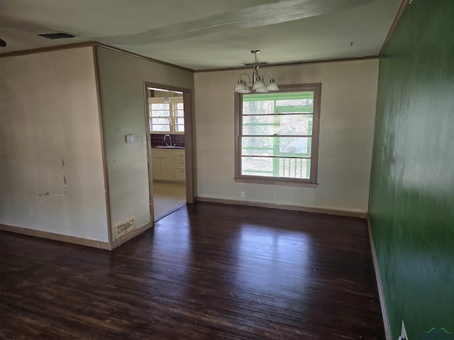 unfurnished dining area with dark wood finished floors, visible vents, an inviting chandelier, ornamental molding, and baseboards