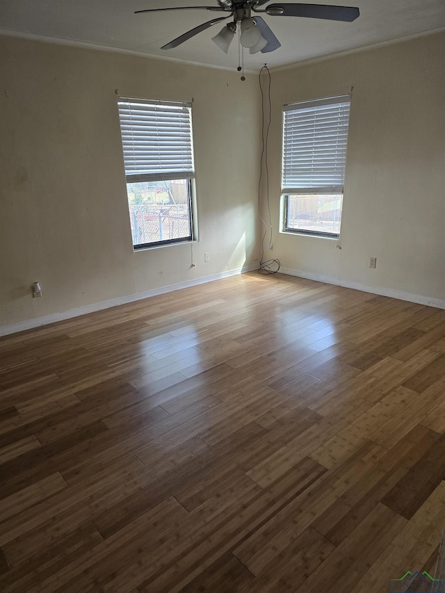 spare room with a ceiling fan, baseboards, ornamental molding, and wood finished floors