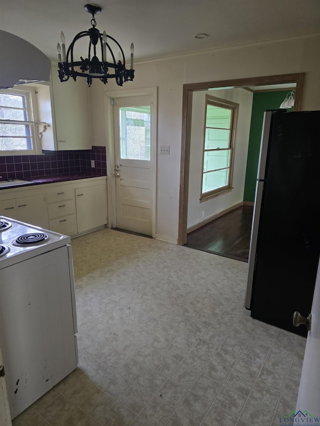 kitchen with electric range, decorative backsplash, freestanding refrigerator, range hood, and white cabinetry