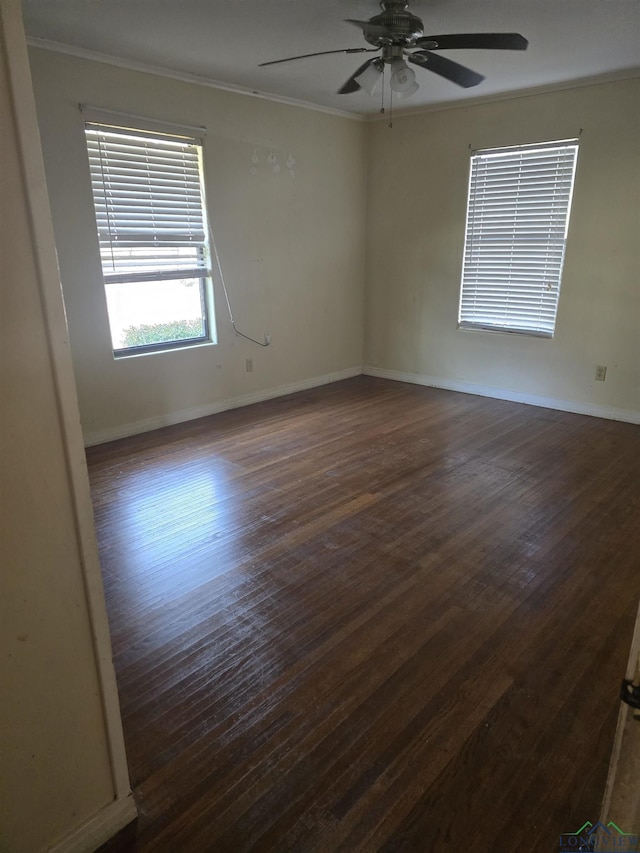 spare room featuring ceiling fan, baseboards, dark wood-style flooring, and crown molding