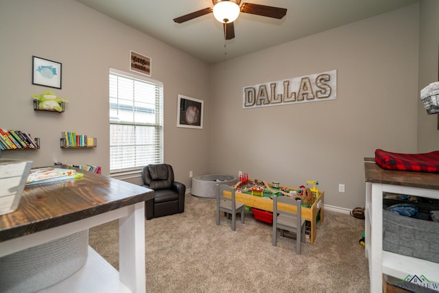 rec room with ceiling fan and light carpet