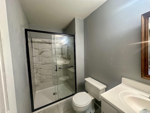 bathroom featuring tile patterned flooring, vanity, toilet, and a shower with door