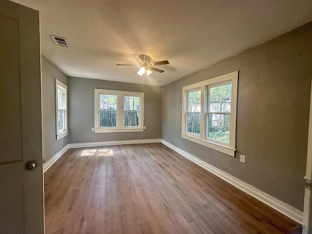 spare room with ceiling fan and light wood-type flooring