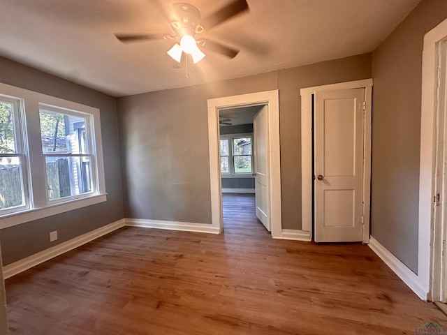 unfurnished room featuring wood-type flooring, ceiling fan, and a healthy amount of sunlight