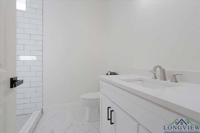 bathroom with vanity, toilet, and a tile shower