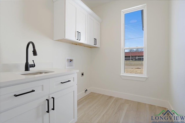 laundry area featuring sink, cabinets, hookup for a washing machine, electric dryer hookup, and light hardwood / wood-style floors