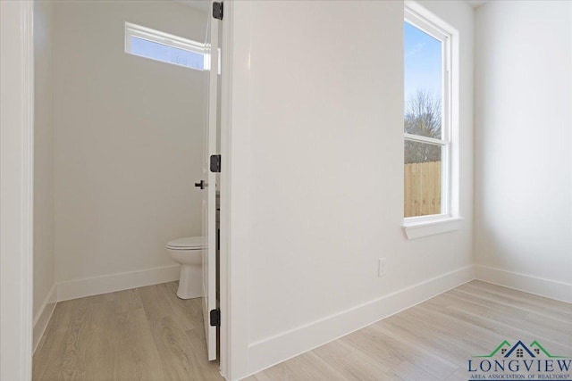 bathroom with hardwood / wood-style flooring, plenty of natural light, and toilet