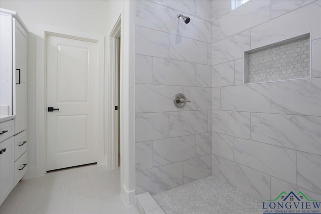 bathroom with vanity, tile patterned floors, and tiled shower