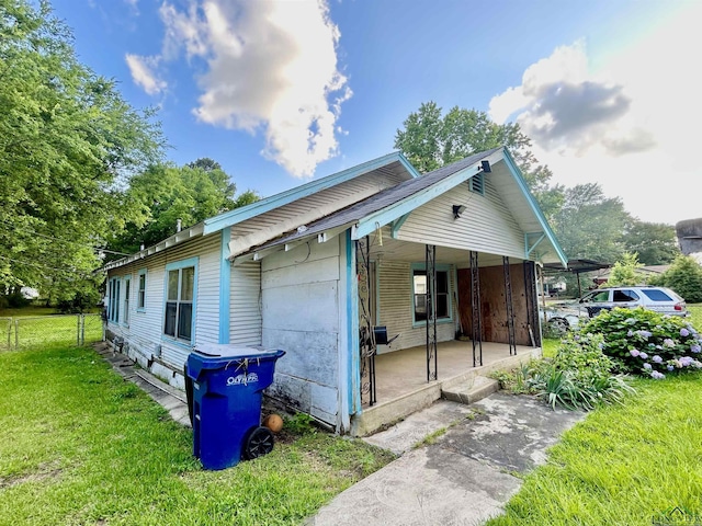 1106 E Level, Longview, TX 75602 - view of side of home featuring covered porch, a lawn, and a carport