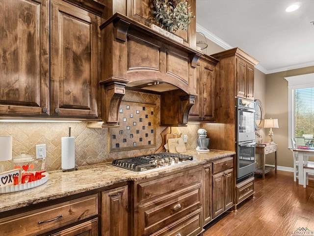 kitchen with crown molding, light stone counters, tasteful backsplash, appliances with stainless steel finishes, and dark hardwood / wood-style flooring