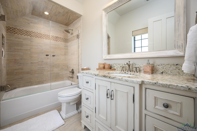 full bathroom with vanity, tiled shower / bath, and toilet