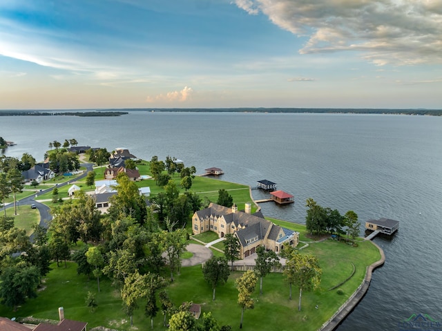 aerial view at dusk featuring a water view