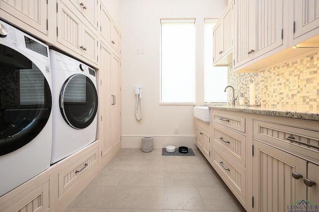 laundry room with light tile patterned flooring, cabinets, and independent washer and dryer