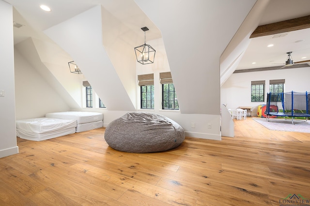 bedroom with beamed ceiling, a chandelier, wood-type flooring, and multiple windows