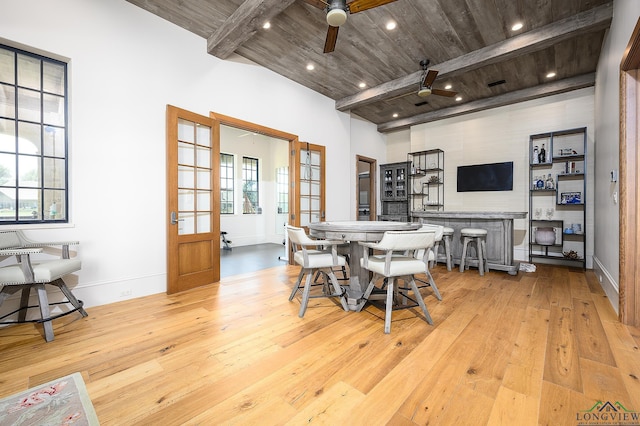 dining area featuring beam ceiling, french doors, wood ceiling, and light wood-type flooring