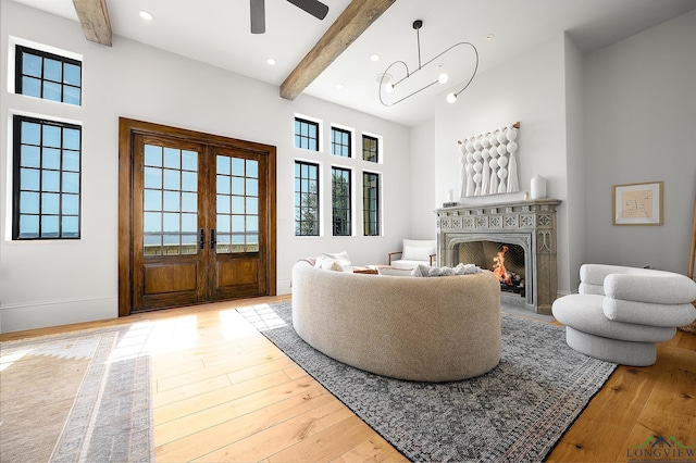 living room with french doors, light hardwood / wood-style flooring, and beam ceiling