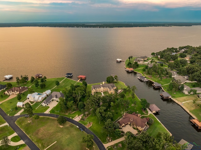 aerial view at dusk featuring a water view