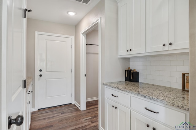 144 Brenlind Ln, Mineola, TX 75773 - kitchen featuring backsplash, white cabinetry, dark wood-style flooring, and light stone counters