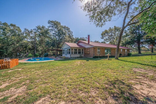 view of yard with a sunroom and a fenced in pool