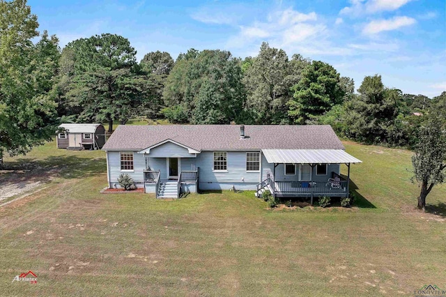 view of front of house featuring a shed, a deck, and a front yard