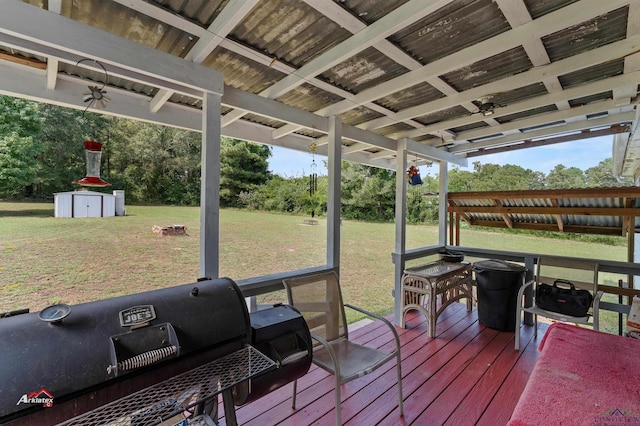 wooden terrace featuring area for grilling, a yard, and a storage shed