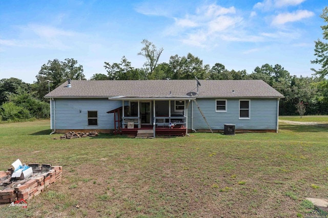 back of property featuring a lawn, central air condition unit, and a sunroom