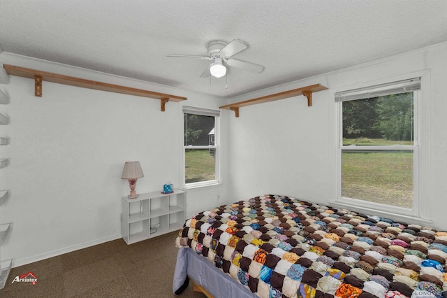 bedroom featuring multiple windows, ceiling fan, and a textured ceiling