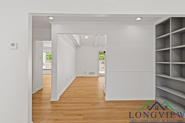 corridor featuring light hardwood / wood-style floors and crown molding