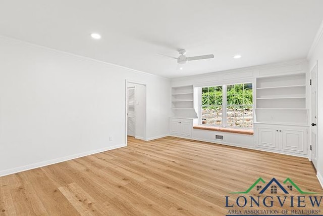 spare room with built in shelves, ceiling fan, ornamental molding, and light hardwood / wood-style flooring