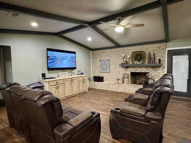 living room featuring brick wall, hardwood / wood-style floors, a brick fireplace, and vaulted ceiling with beams