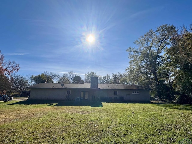 rear view of property with a lawn