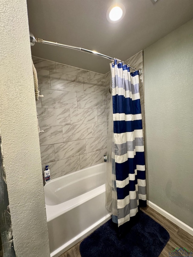 bathroom featuring wood-type flooring and shower / tub combo with curtain