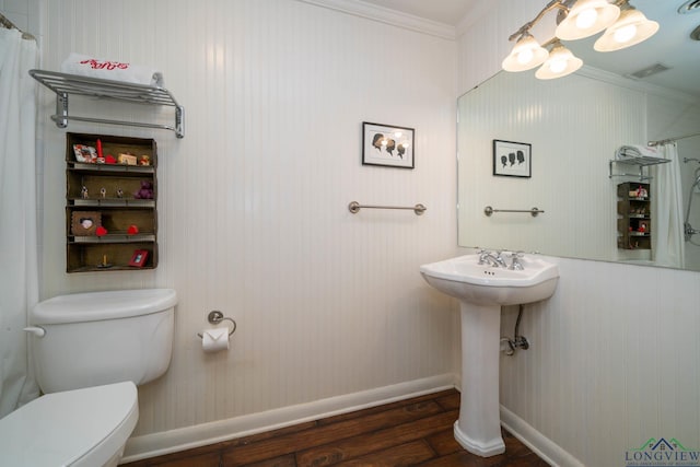 bathroom featuring hardwood / wood-style flooring, toilet, and crown molding